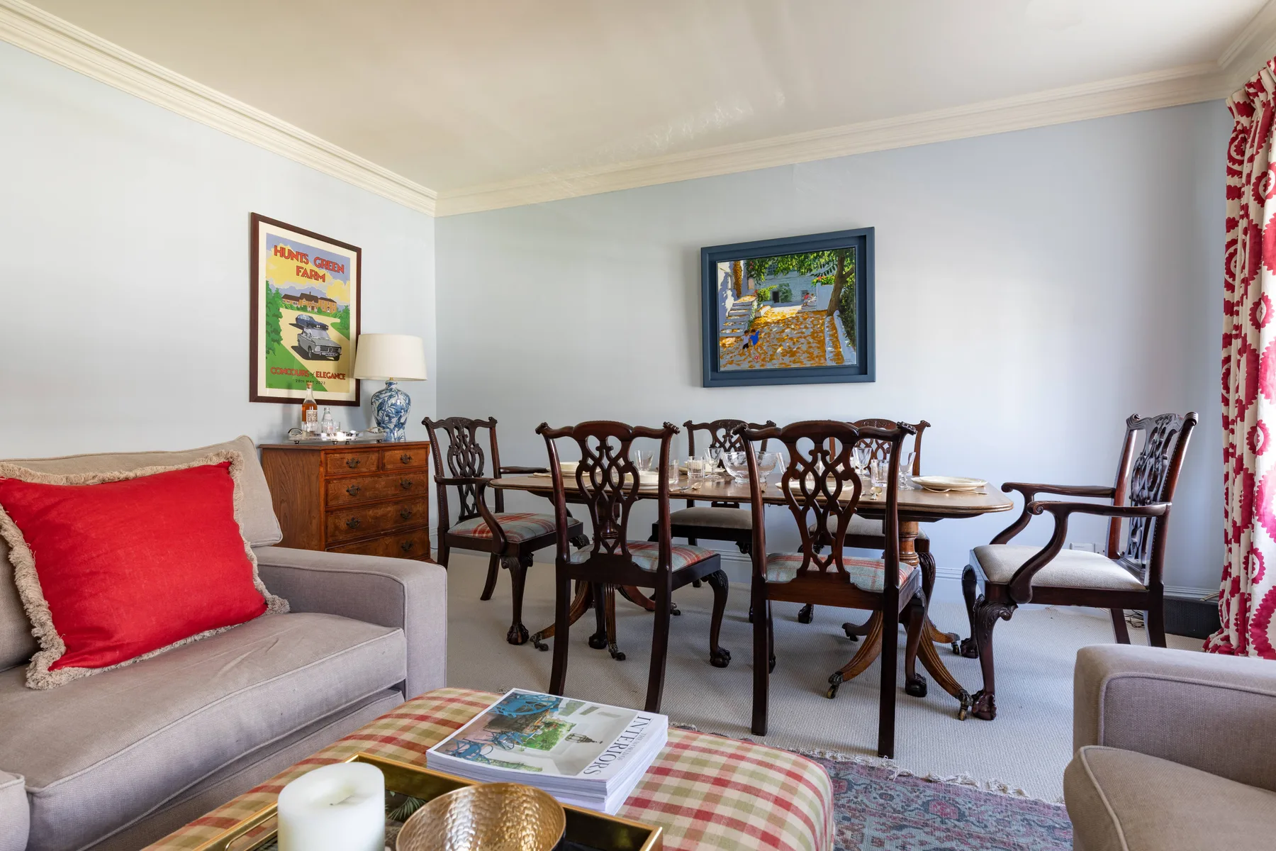 Comedor con una mesa de madera y sillas, junto a una zona de estar.
