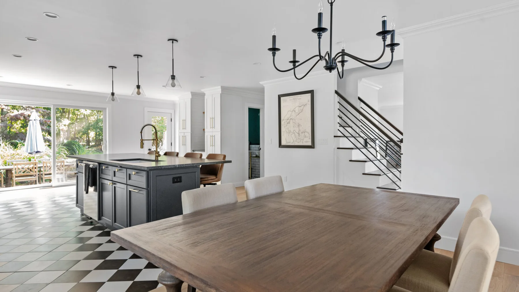 A bright open-plan kitchen and dining area with a large wooden table.