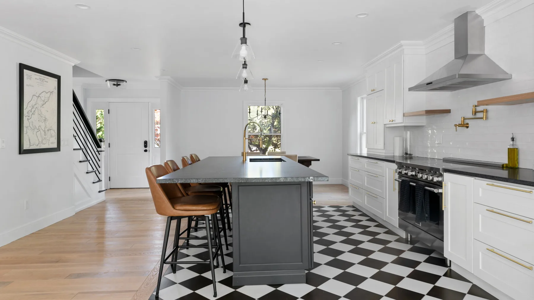 A bright kitchen with a central island and black-and-white checkered flooring.