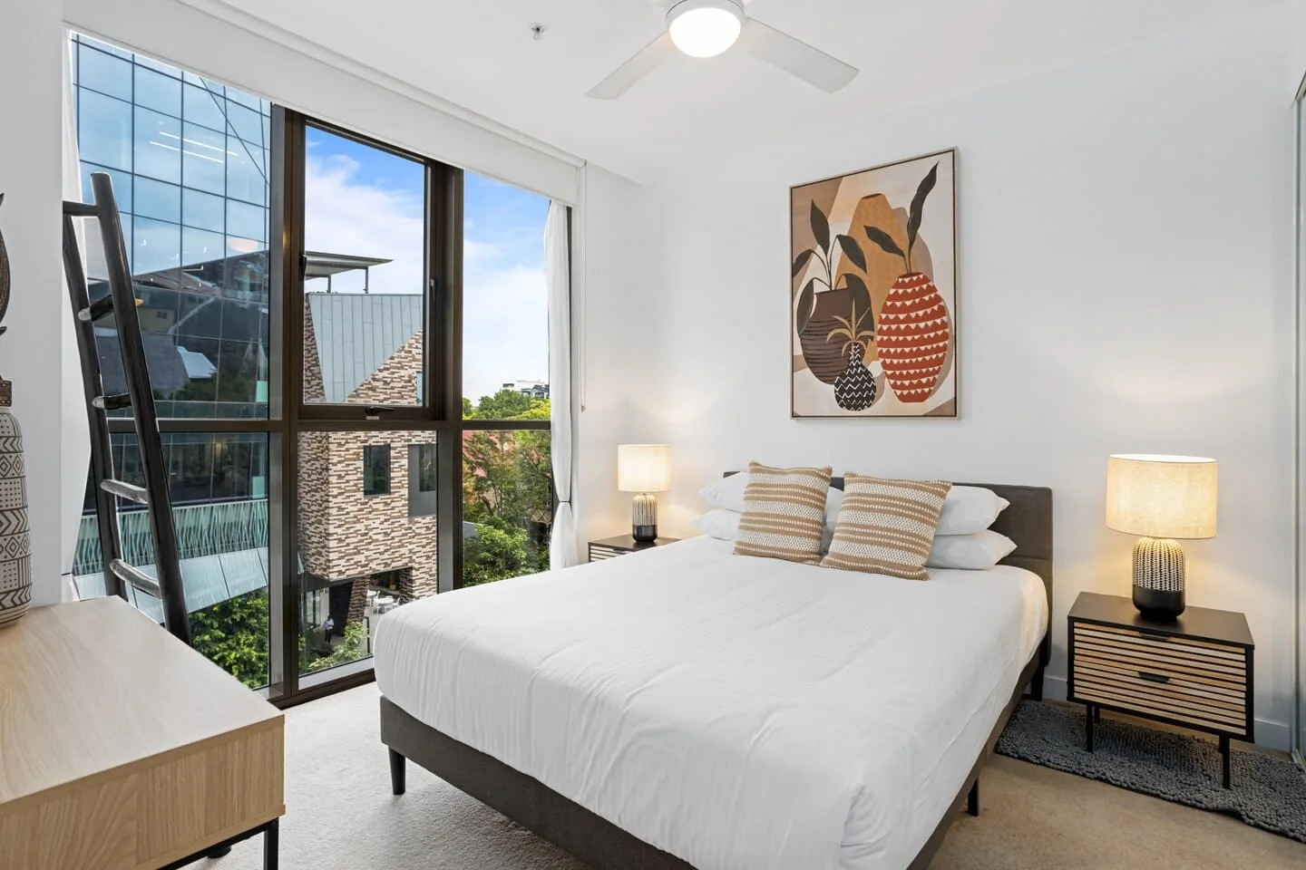 El dormitorio principal destaca por su cama de tamaño queen y sus preciosos ventanales de suelo a techo.