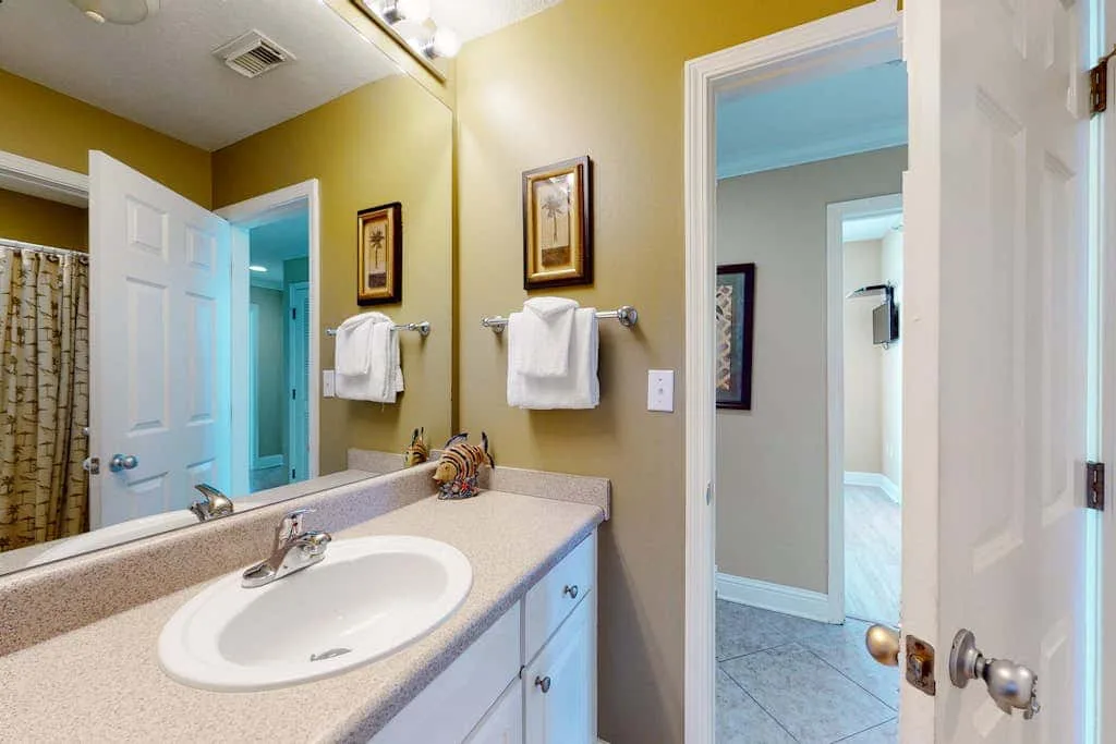A bathroom vanity with a sink and towels hanging on the wall.