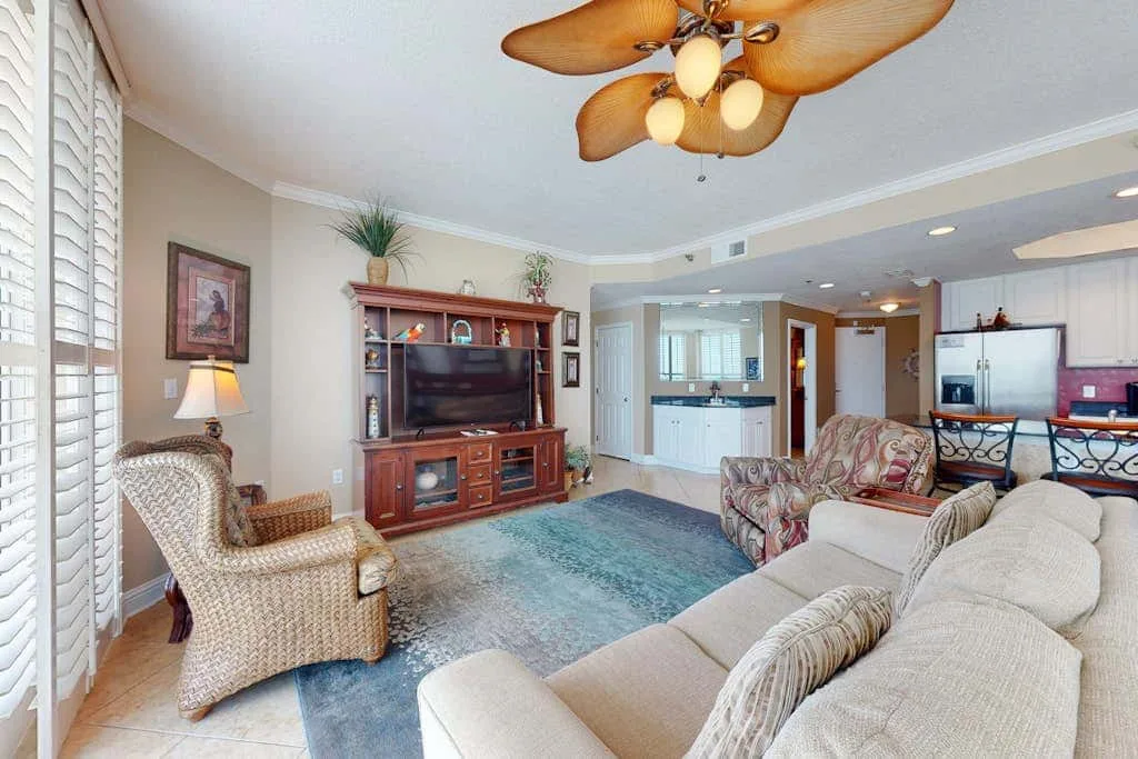 A living room with seating arranged around a television and entertainment cabinet.