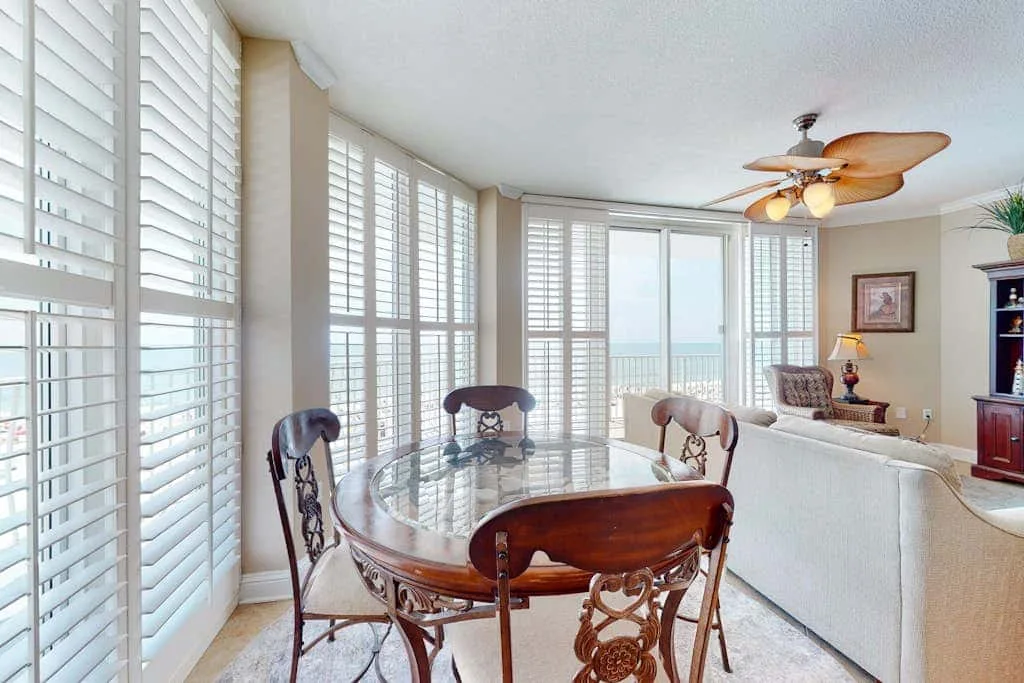 A bright dining area with a round table beside large windows.