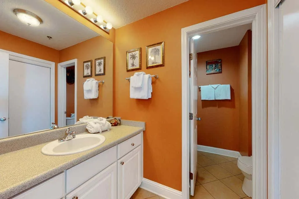 A bathroom with a sink and towels beside an open doorway.