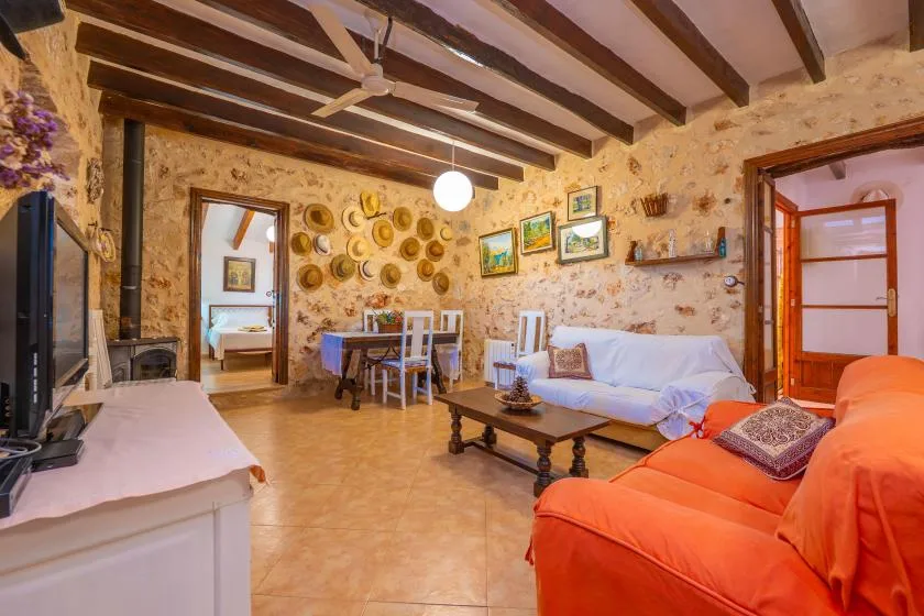 Una sala rústica con asientos, una mesa de comedor y vigas expuestas en el techo.