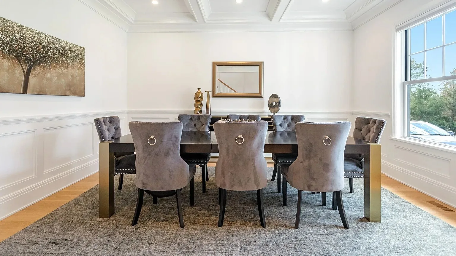 Comedor con una mesa larga y asientos tapizados bajo un techo con paneles.