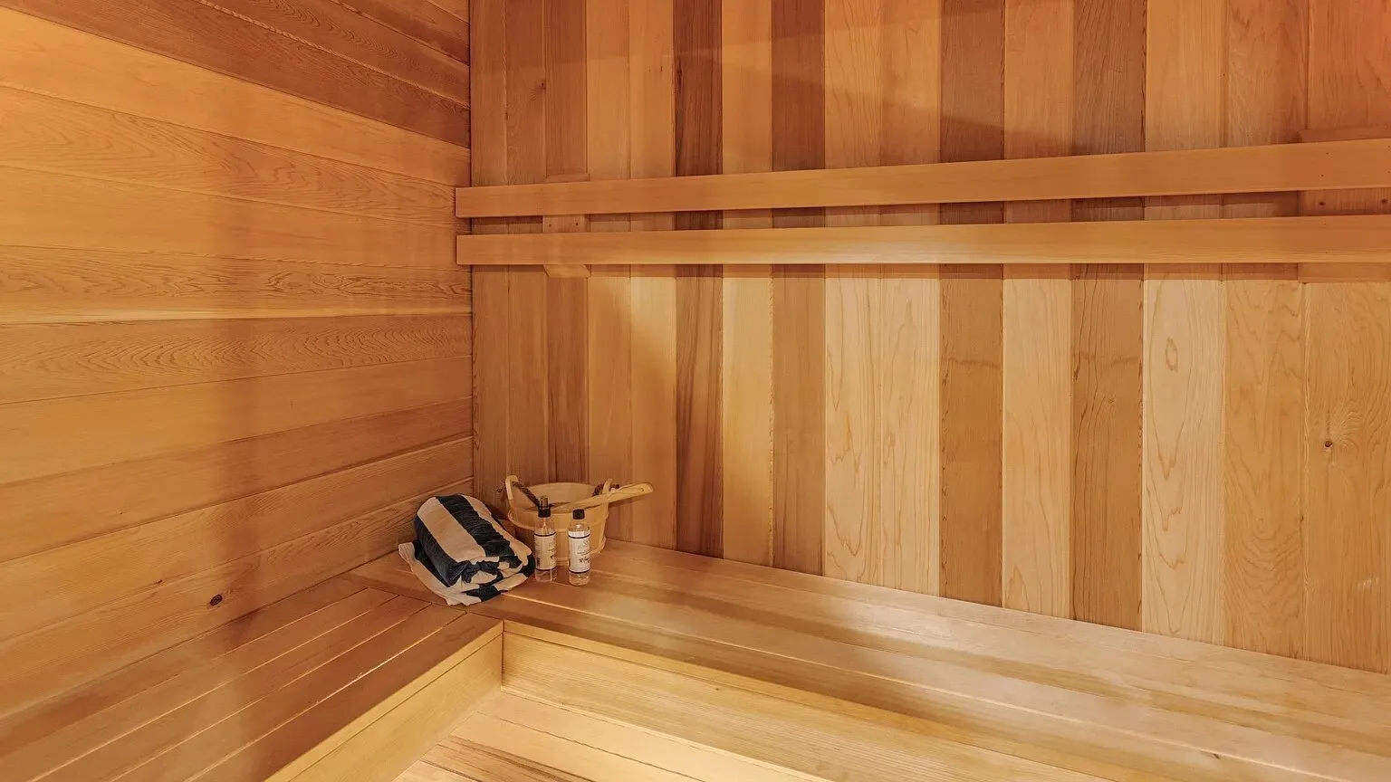 Una sauna revestida de madera con asientos de distintos niveles.