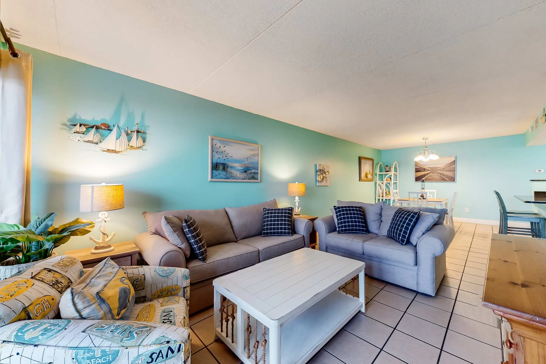 A bright living room with seating arranged around a white coffee table.