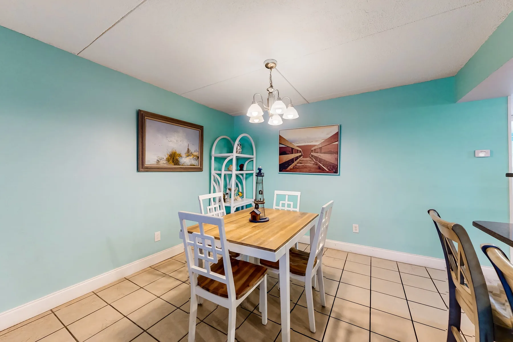 A dining area with a wooden table, seating, and turquoise walls.