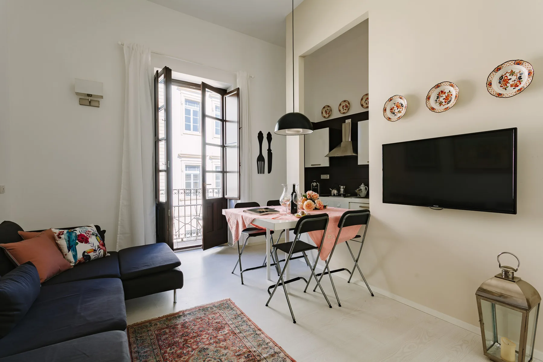Una sala de estar y comedor con una zona de asientos oscura junto a una mesa.