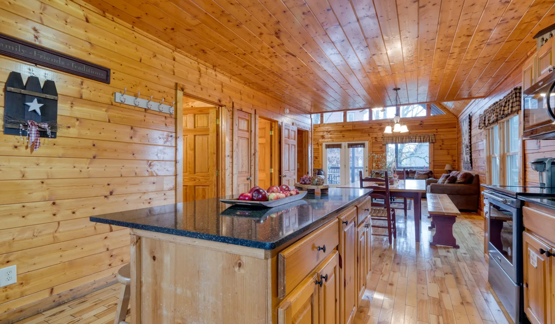 Una cocina revestida de madera se abre a un comedor y una sala de estar.