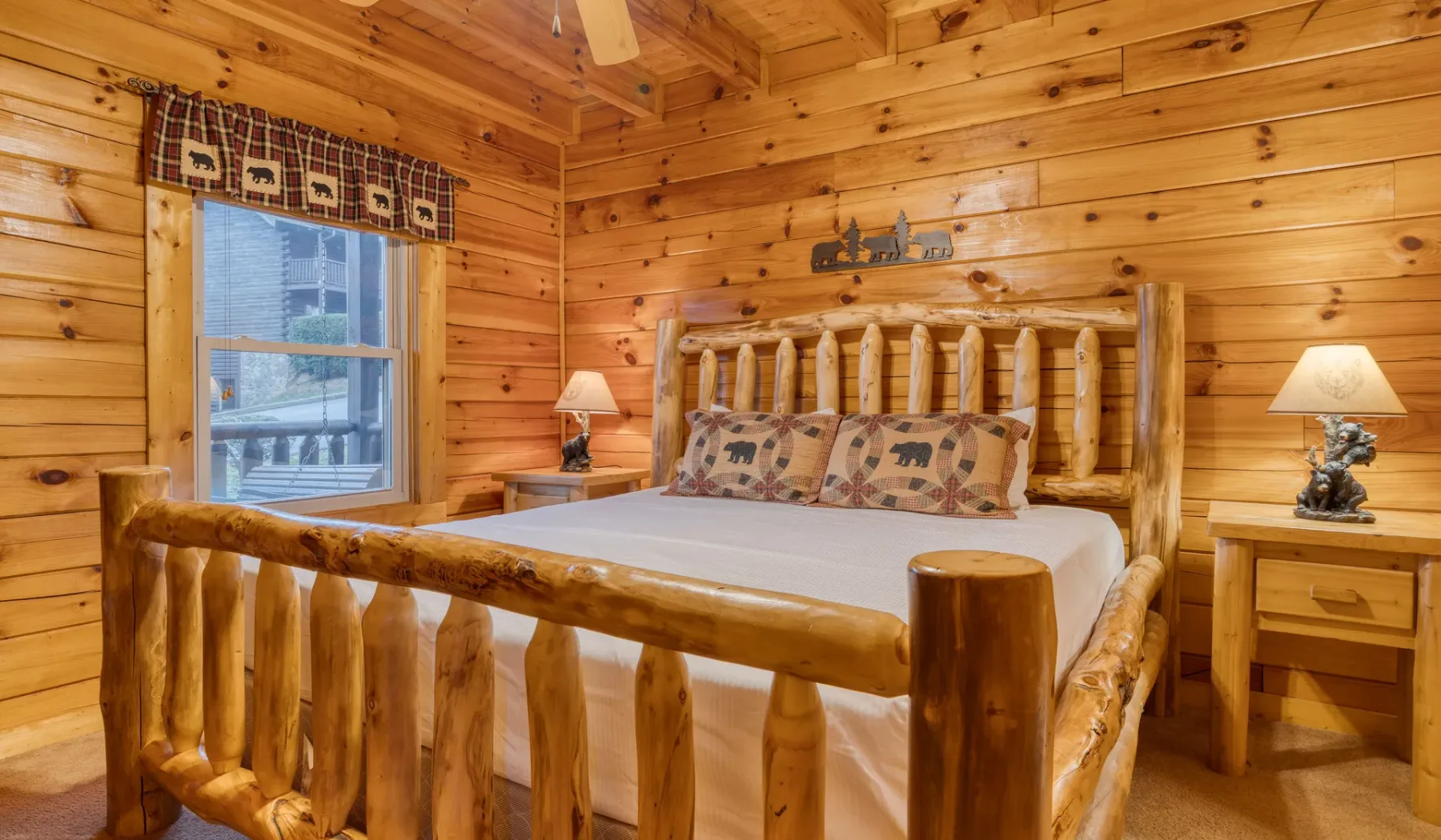 Un dormitorio con una cama de troncos, mesas de noche y paredes de madera.