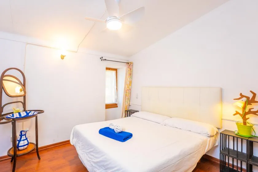 A bright bedroom with a large bed and a window.