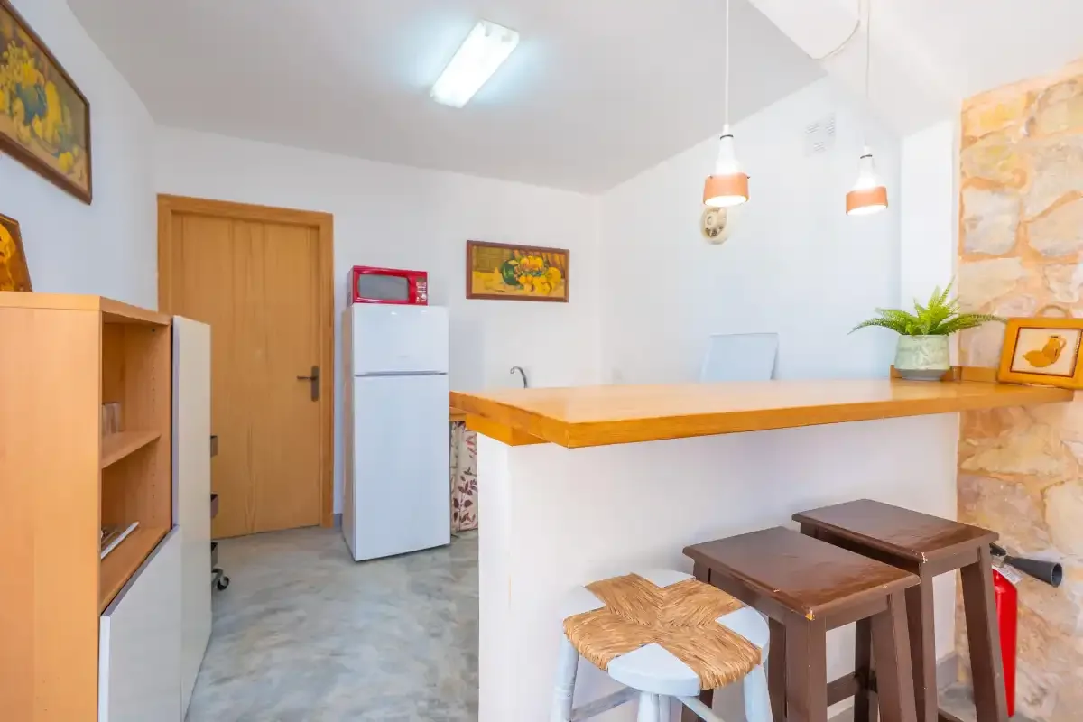 A kitchenette with a refrigerator and a wooden counter.