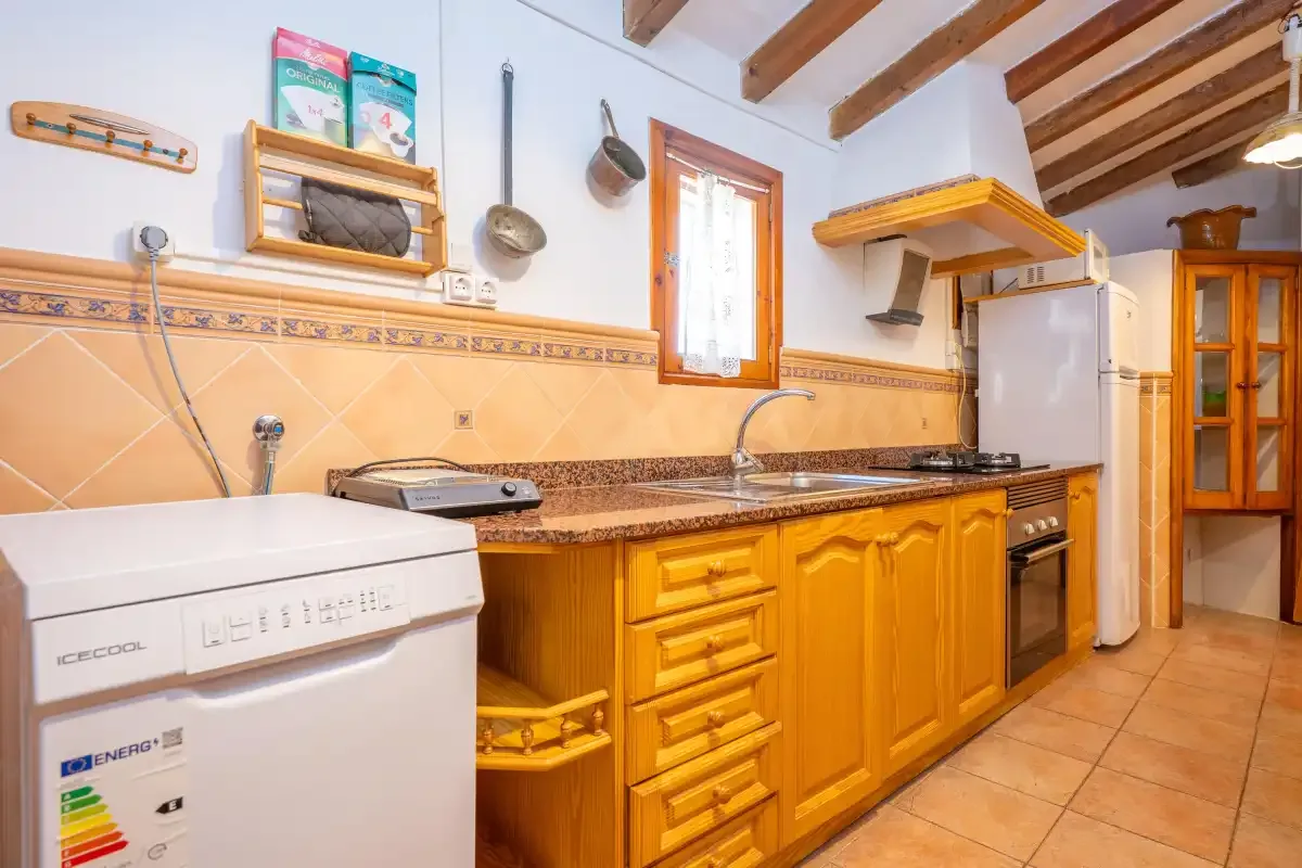 A kitchen with wooden cabinets, a countertop, and cooking appliances.