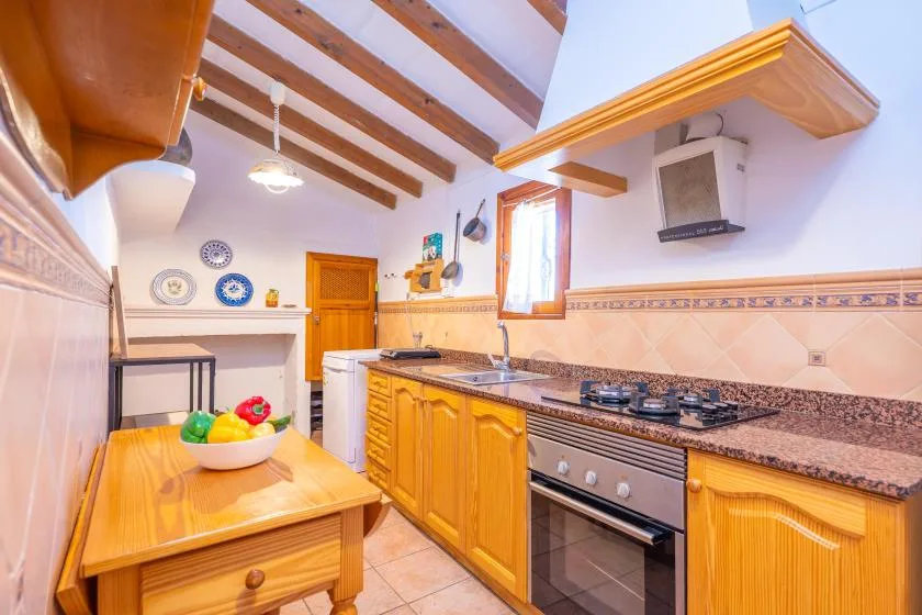 A bright kitchen with wooden cabinets and a countertop cooktop.