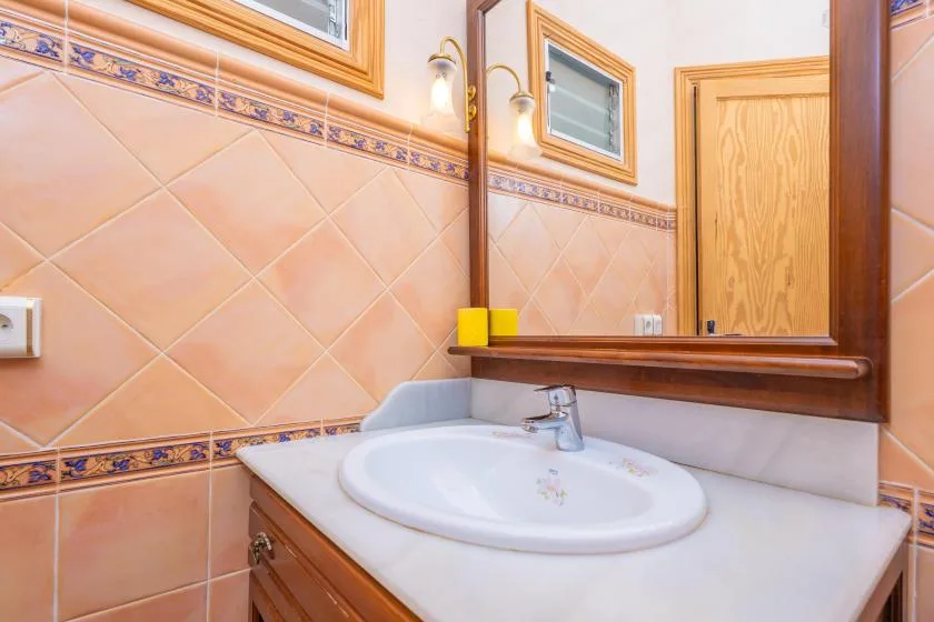 A bathroom vanity with a white sink and mirror.