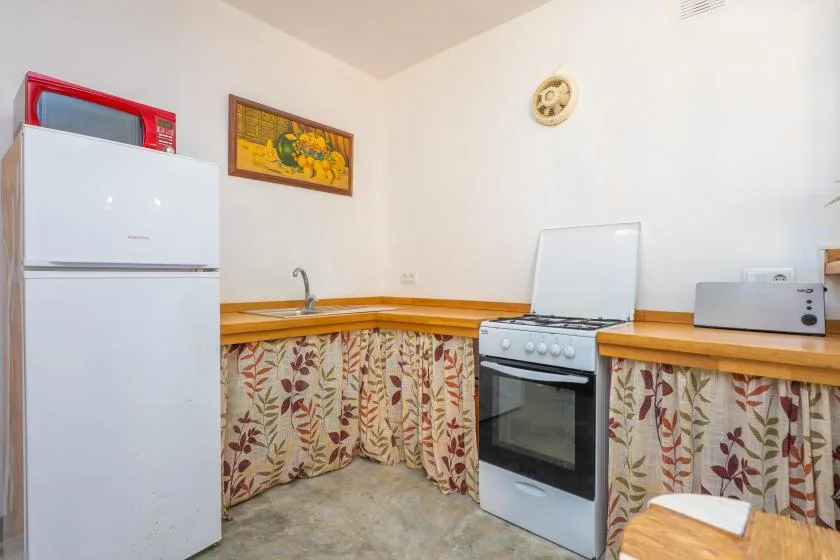 A compact kitchen with a refrigerator, stove, and counters.