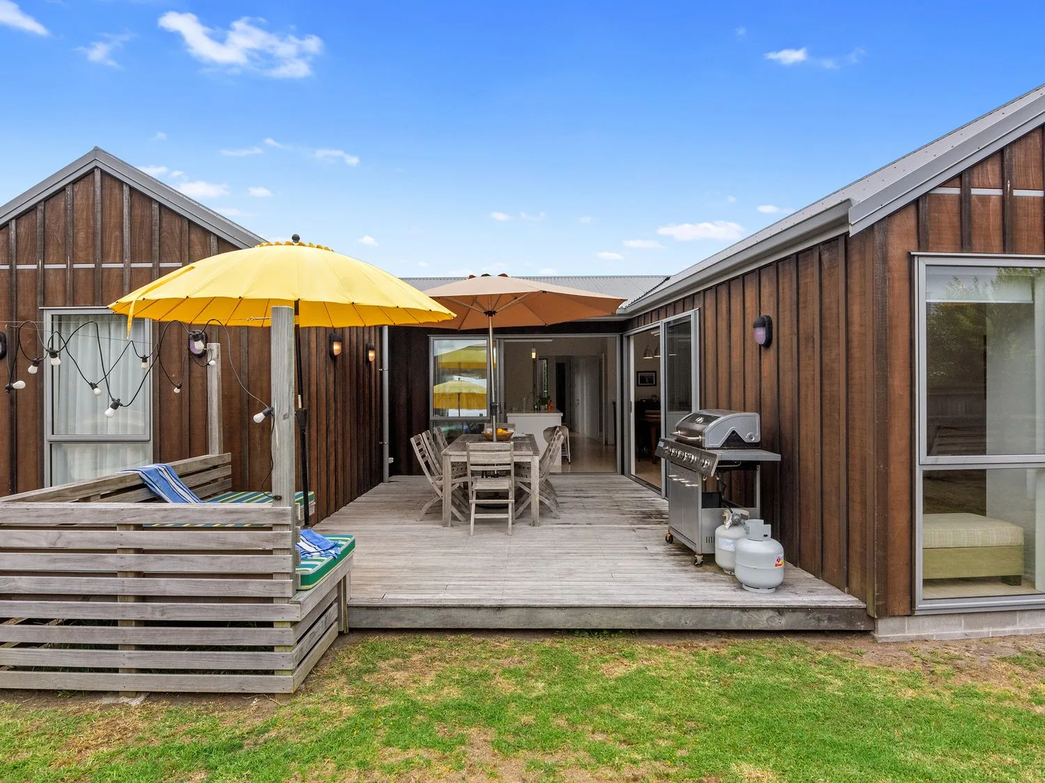 Una zona exterior con una terraza de madera y muebles en White Sands Haven - Omaha