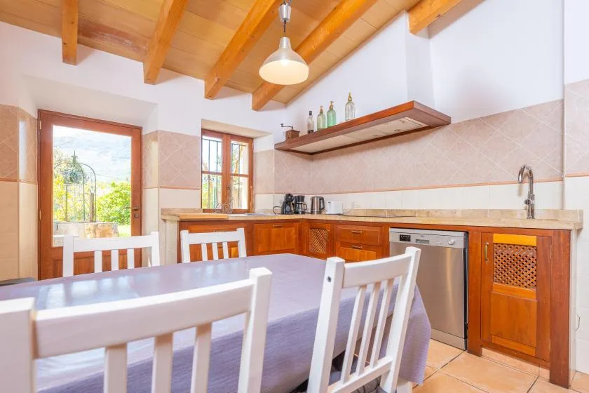 A bright kitchen and dining area with wooden cabinetry and a table.
