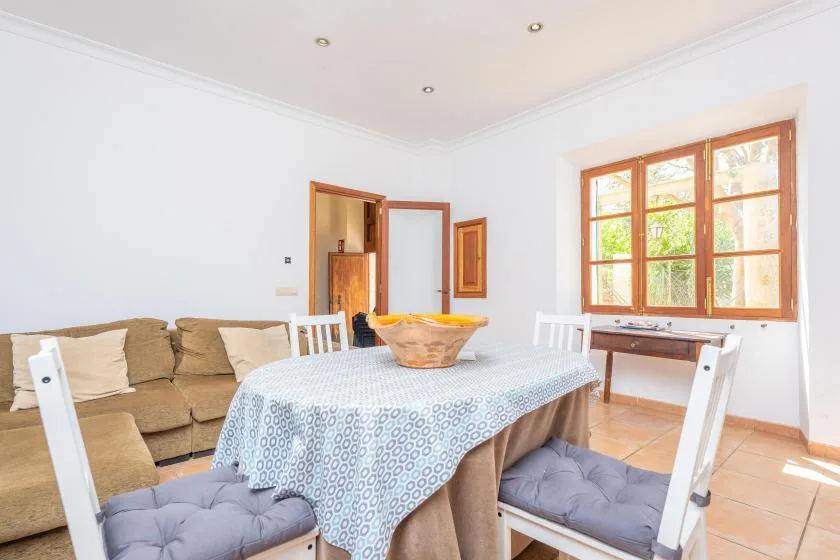 A bright dining area with a table beside a large wood-framed window.