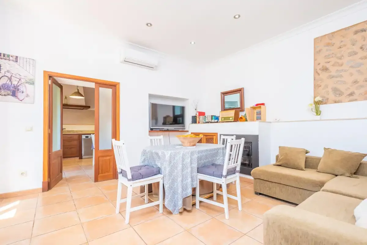 A bright living and dining area with a table, chairs, and seating.