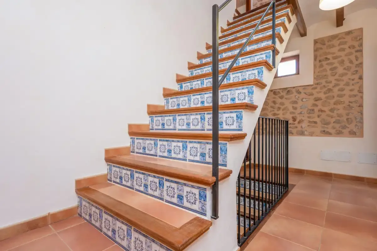 A tiled staircase rises beside a stone accent wall.
