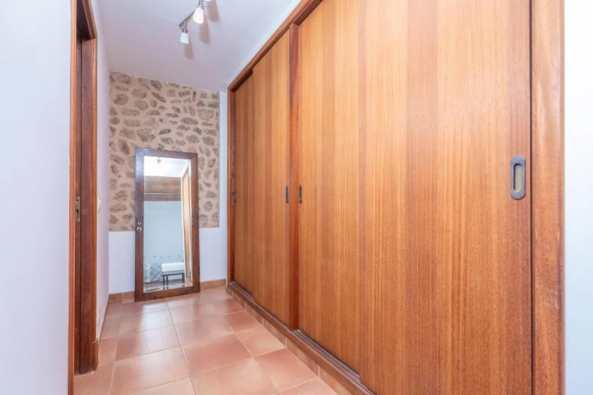 A hallway with large wooden sliding doors and a tiled floor.