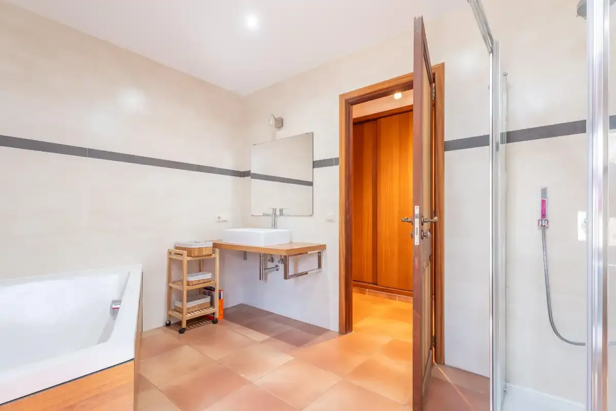 A bright bathroom with a bathtub, sink, and glass shower.
