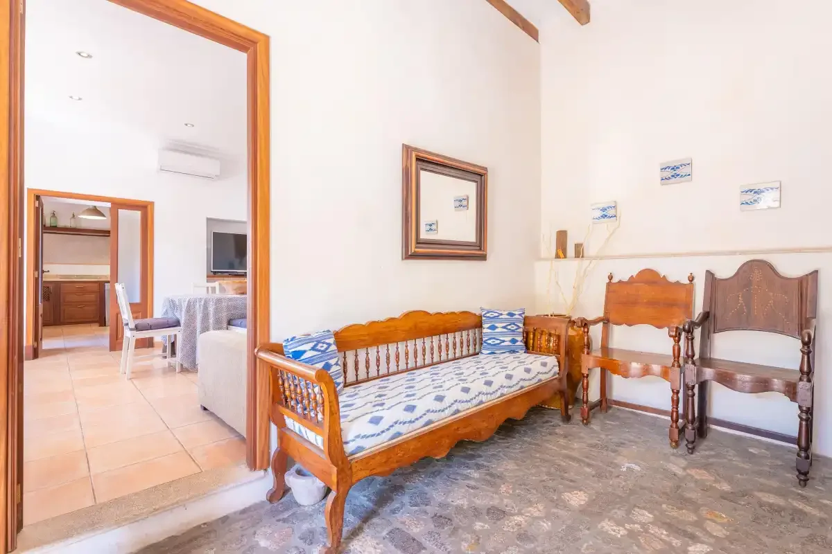 A sitting room with a wooden daybed and chairs.