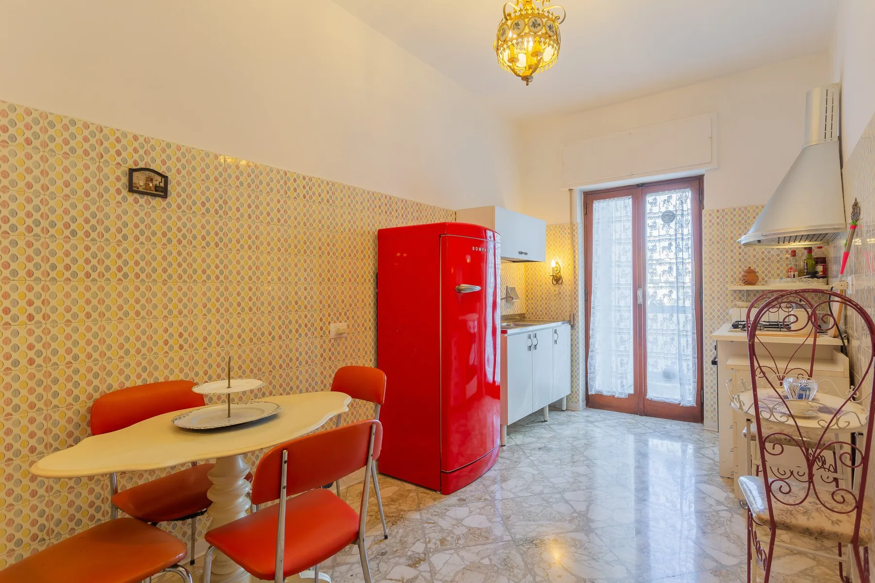 A kitchen and dining area with a red refrigerator and a table with seating.