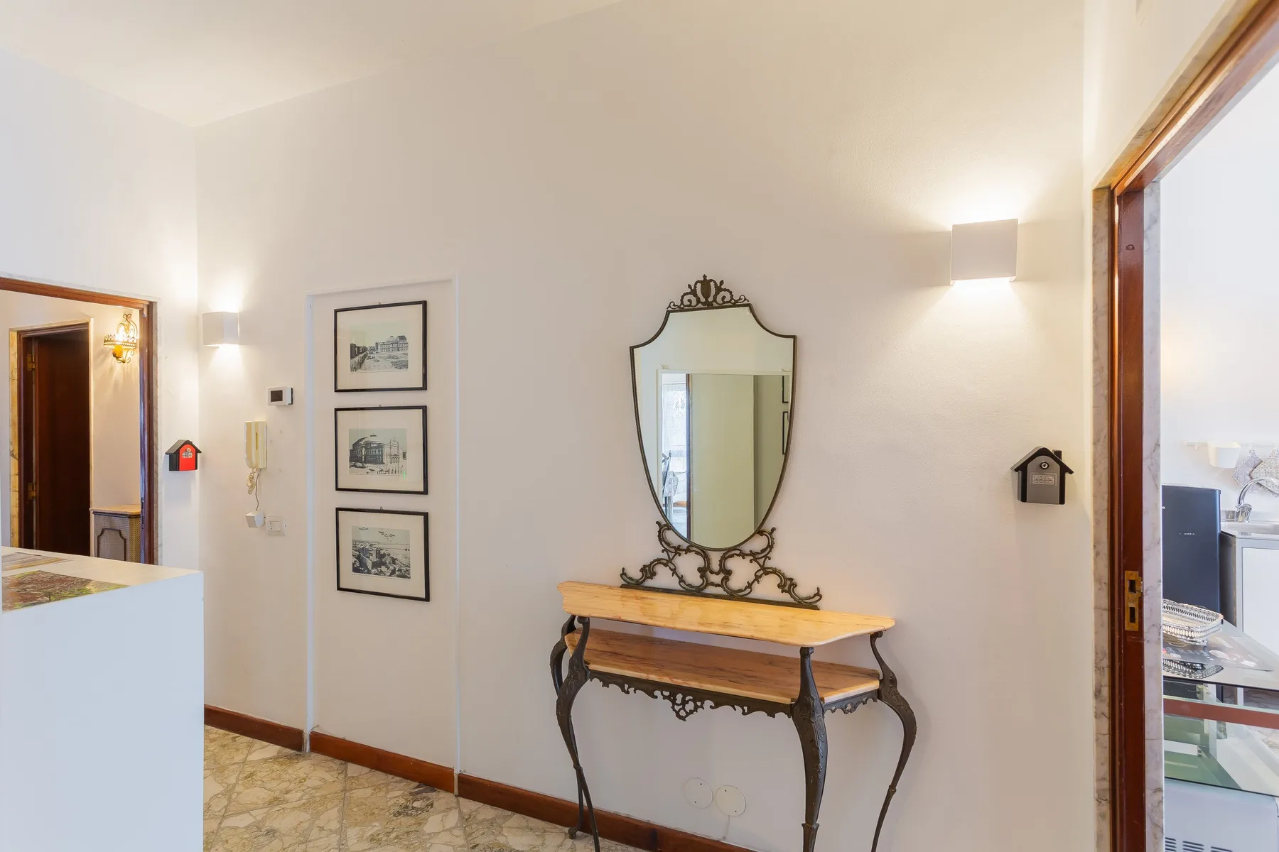 A bright entry hall features a decorative mirror above a narrow console table.