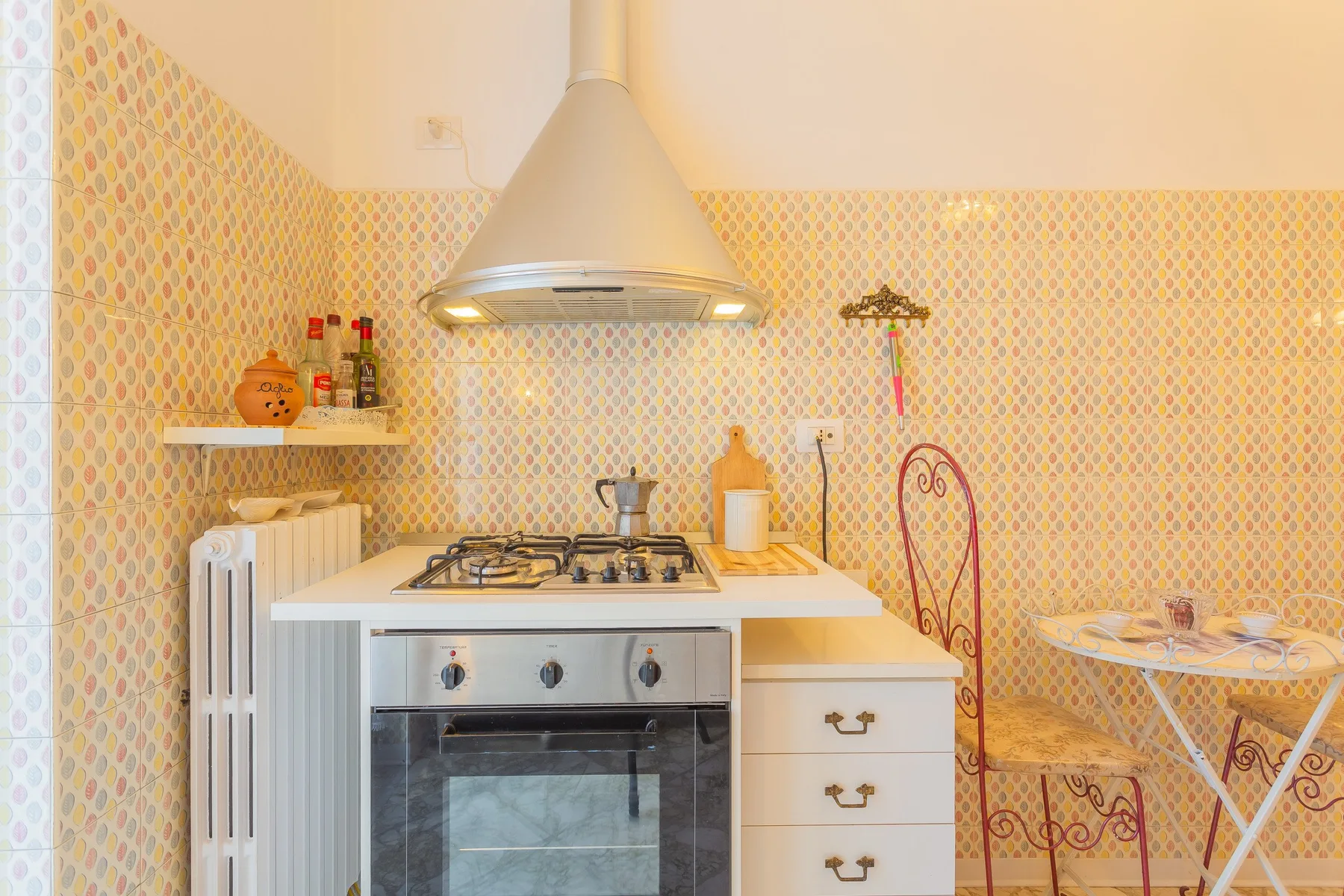 A small kitchen with a gas cooktop, oven, and round table.