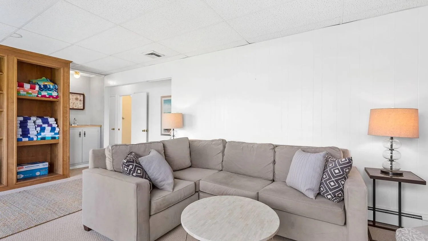 A living room with a large sectional sofa and a round coffee table.