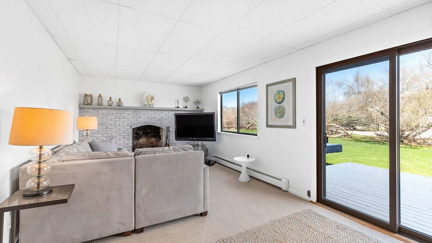 A living room with seating, a fireplace, and sliding glass doors opening onto a patio.