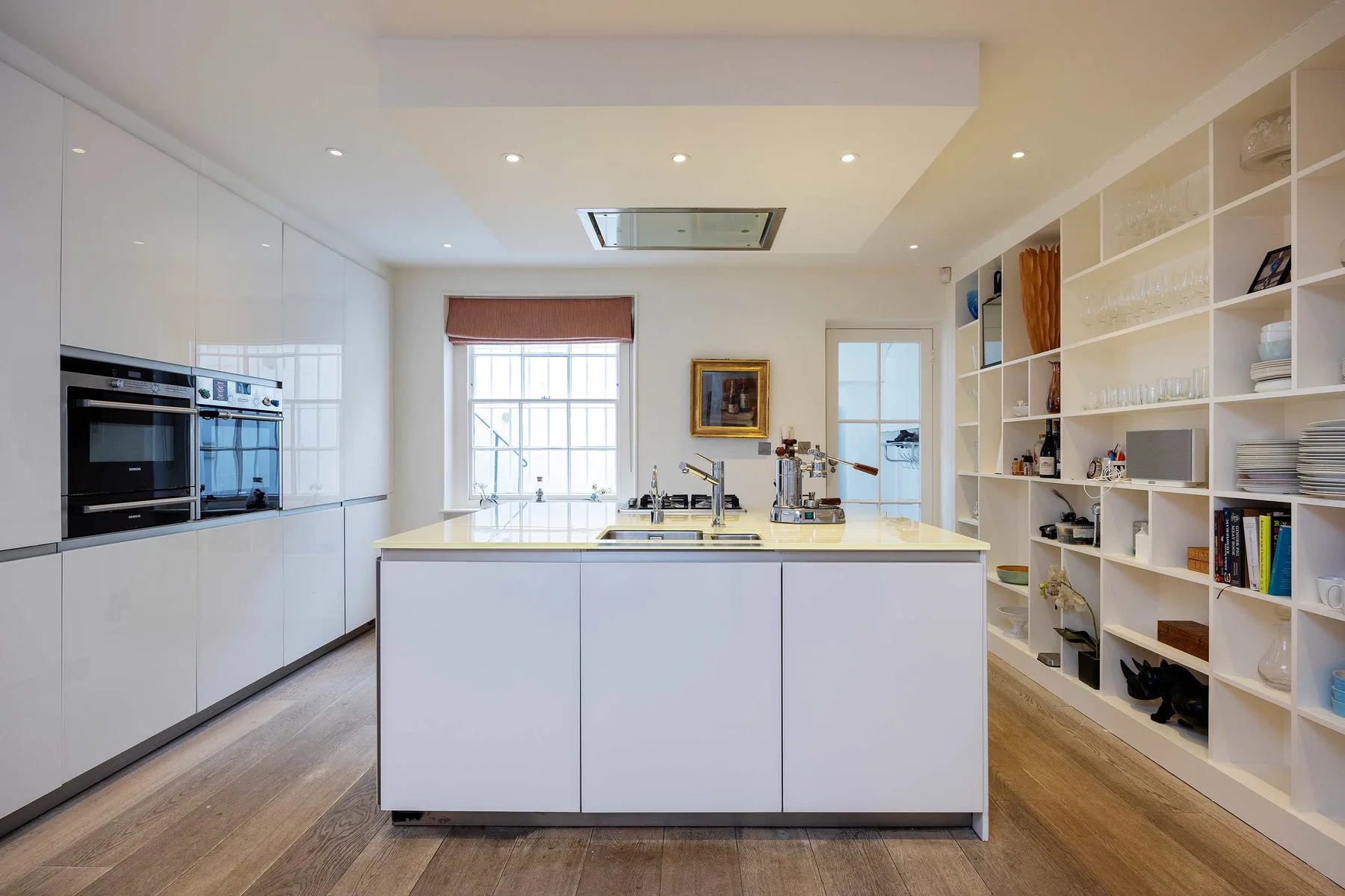 Una cocina luminosa con una isla central y electrodomésticos integrados.