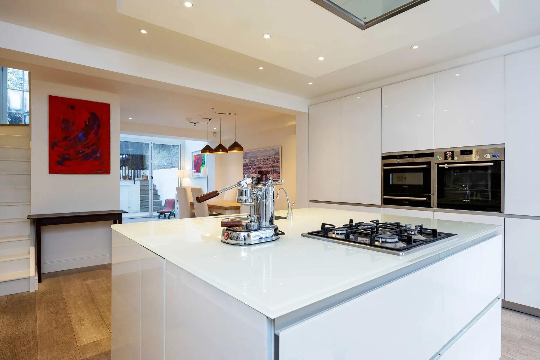 Una cocina moderna y luminosa con una isla grande y electrodomésticos integrados.