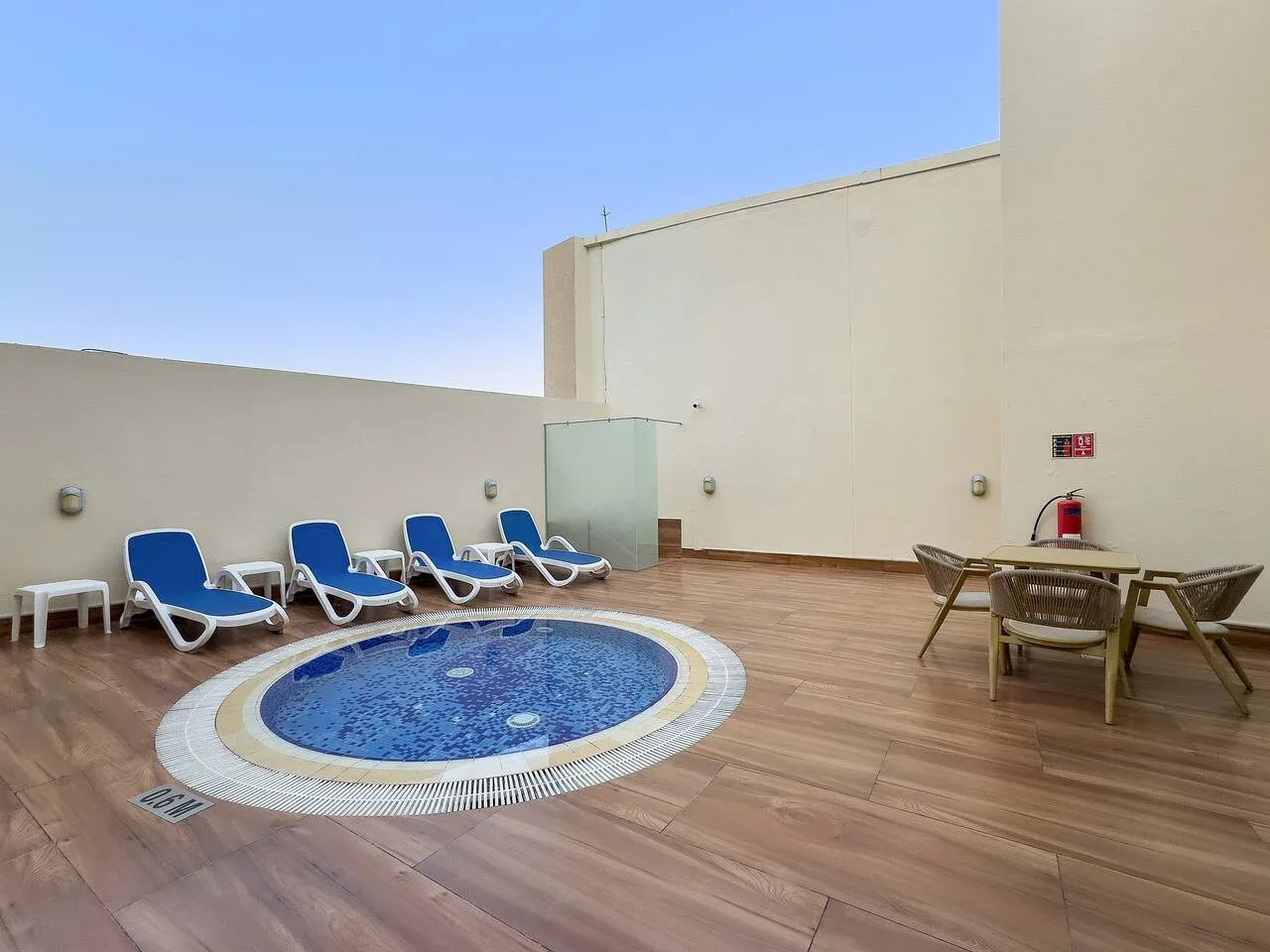 Una zona de piscina al aire libre con una pequeña piscina circular y asientos.