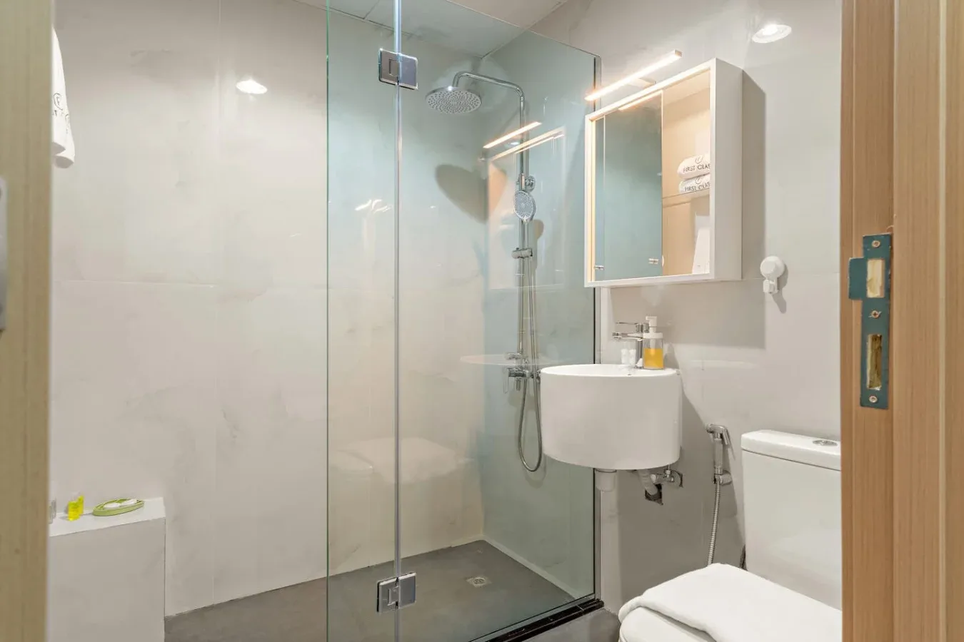 Un baño con ducha de vidrio, lavabo y espejo.