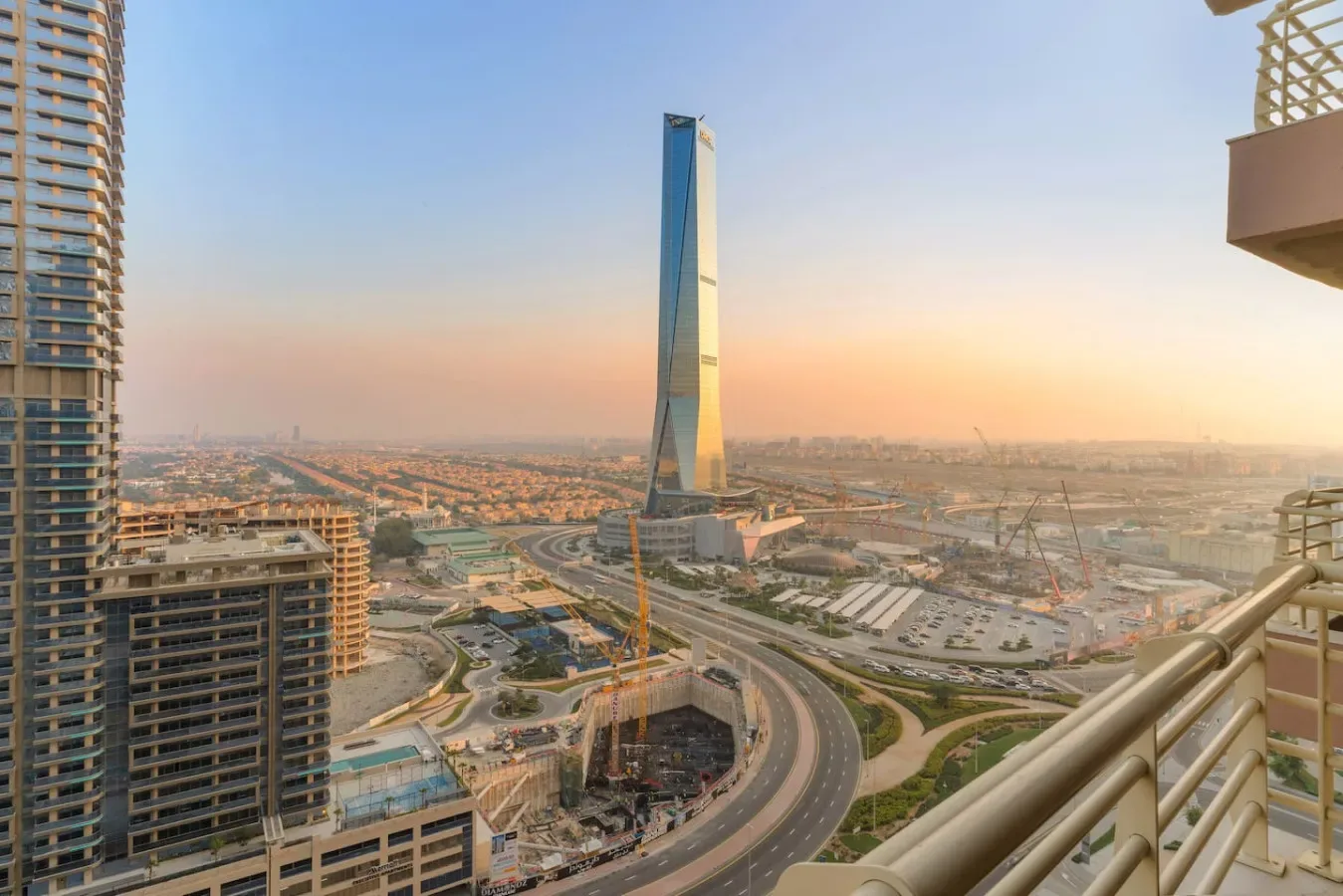 Un horizonte urbano con una torre alta y distintiva sobre carreteras curvas.
