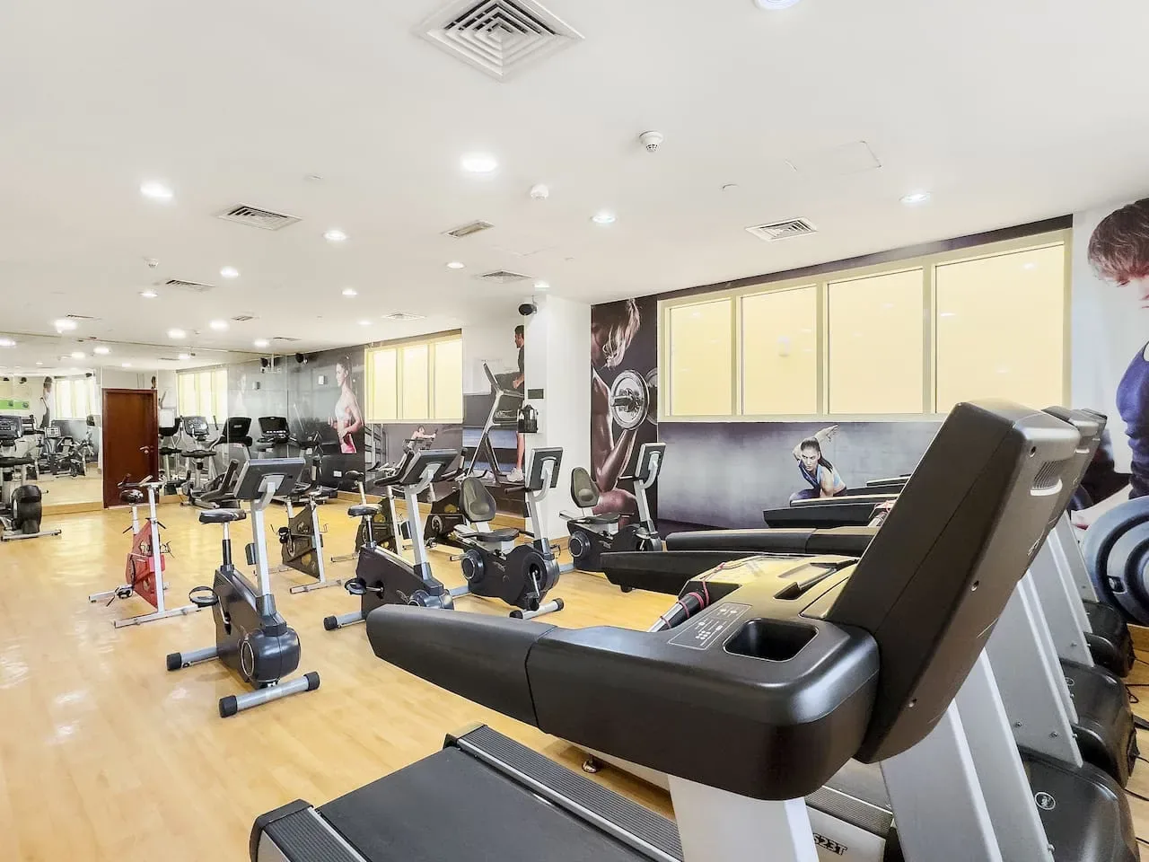 Un gimnasio luminoso con bicicletas estáticas y equipo de entrenamiento con pesas.
