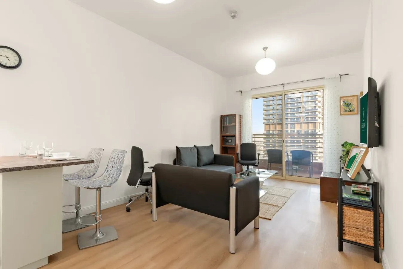 Una sala luminosa con asientos, una barra de comedor y ventanas grandes.