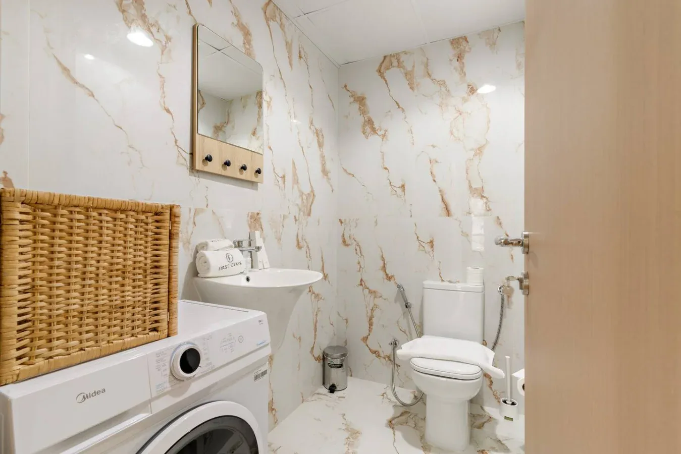 Un baño con lavadora, lavabo e inodoro.