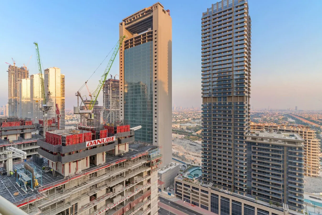 Un horizonte urbano con edificios altos y grúas de construcción.