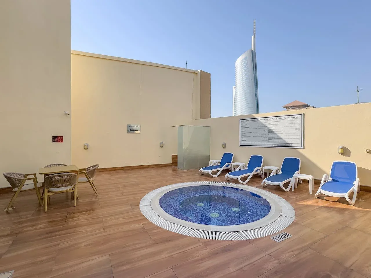 Zona de piscina en la azotea con tumbonas azules y una pequeña piscina circular.