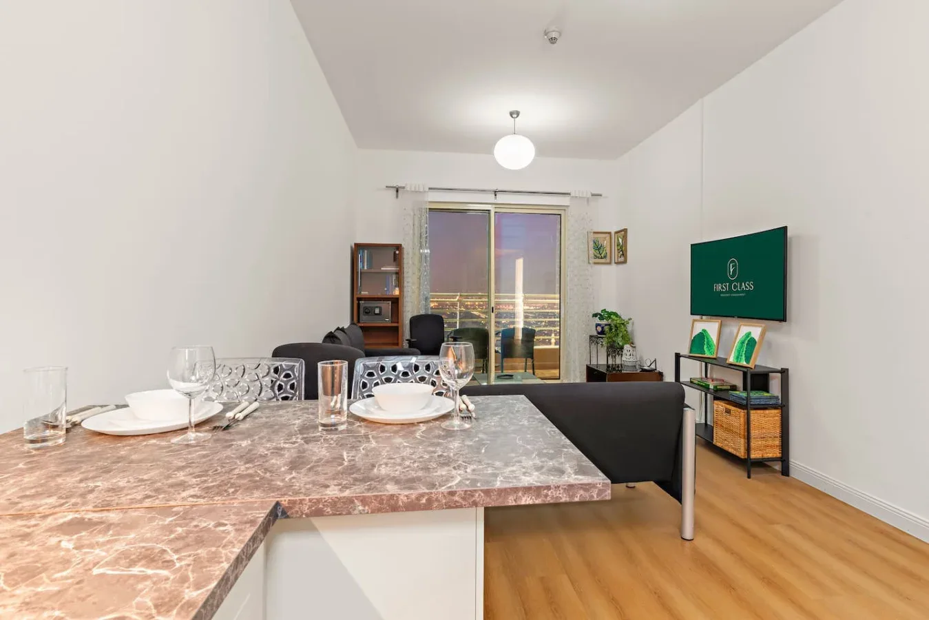 Comedor con una encimera de diseño marmoleado, junto a una sala y puertas de balcón.