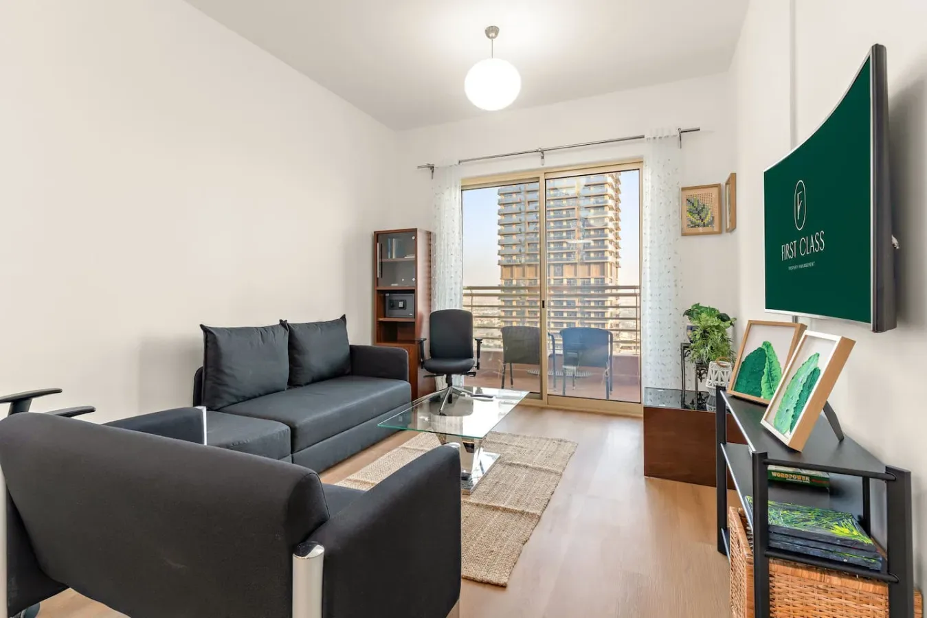 Una sala luminosa con asientos, una mesa de centro y una ventana con edificios cercanos a la vista.