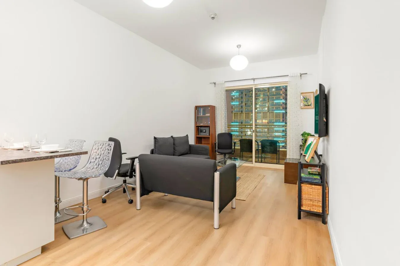 Una sala luminosa con asientos, una barra de comedor y puertas de vidrio.