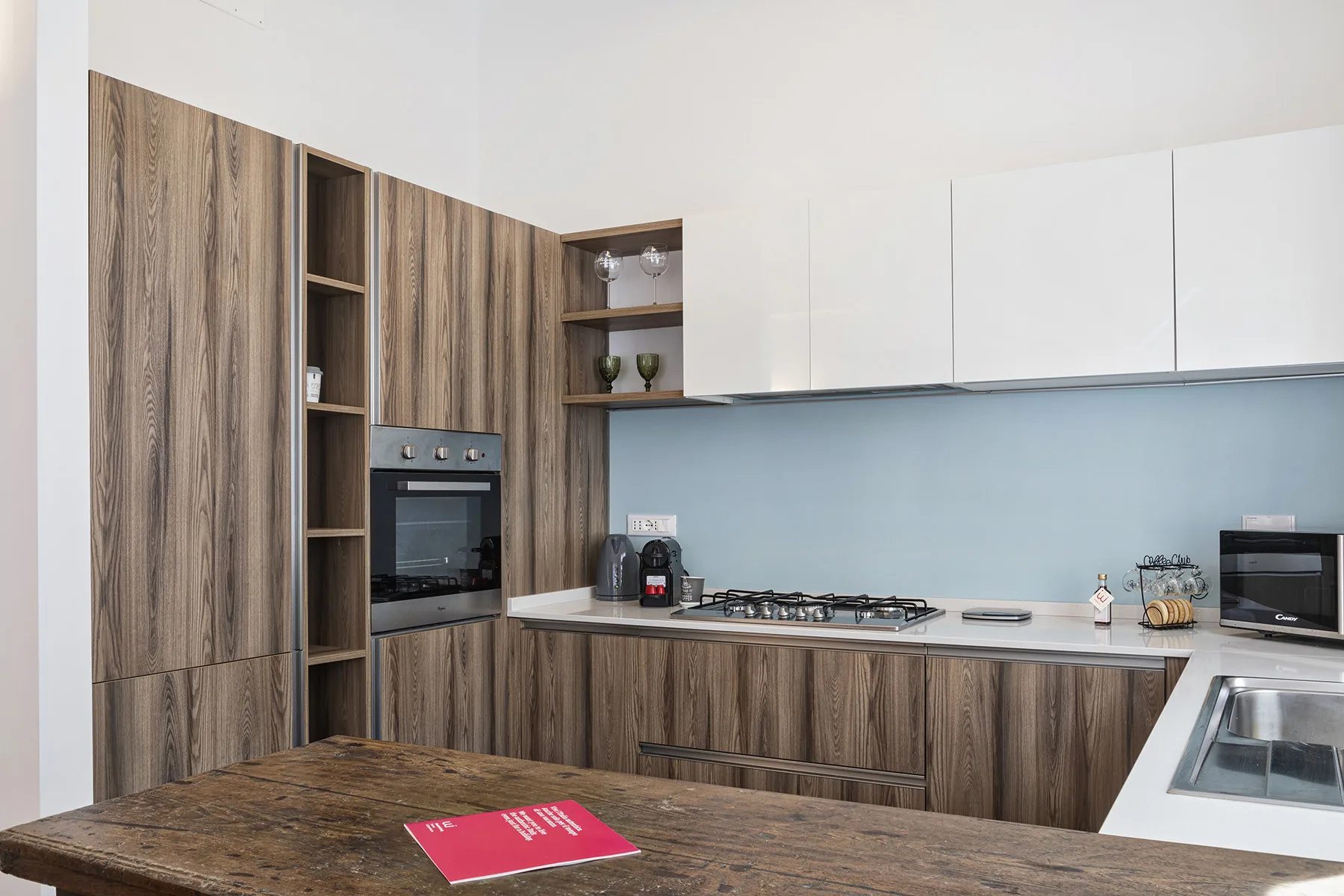 A modern kitchen with wood-grain cabinets, a cooktop, and a countertop.