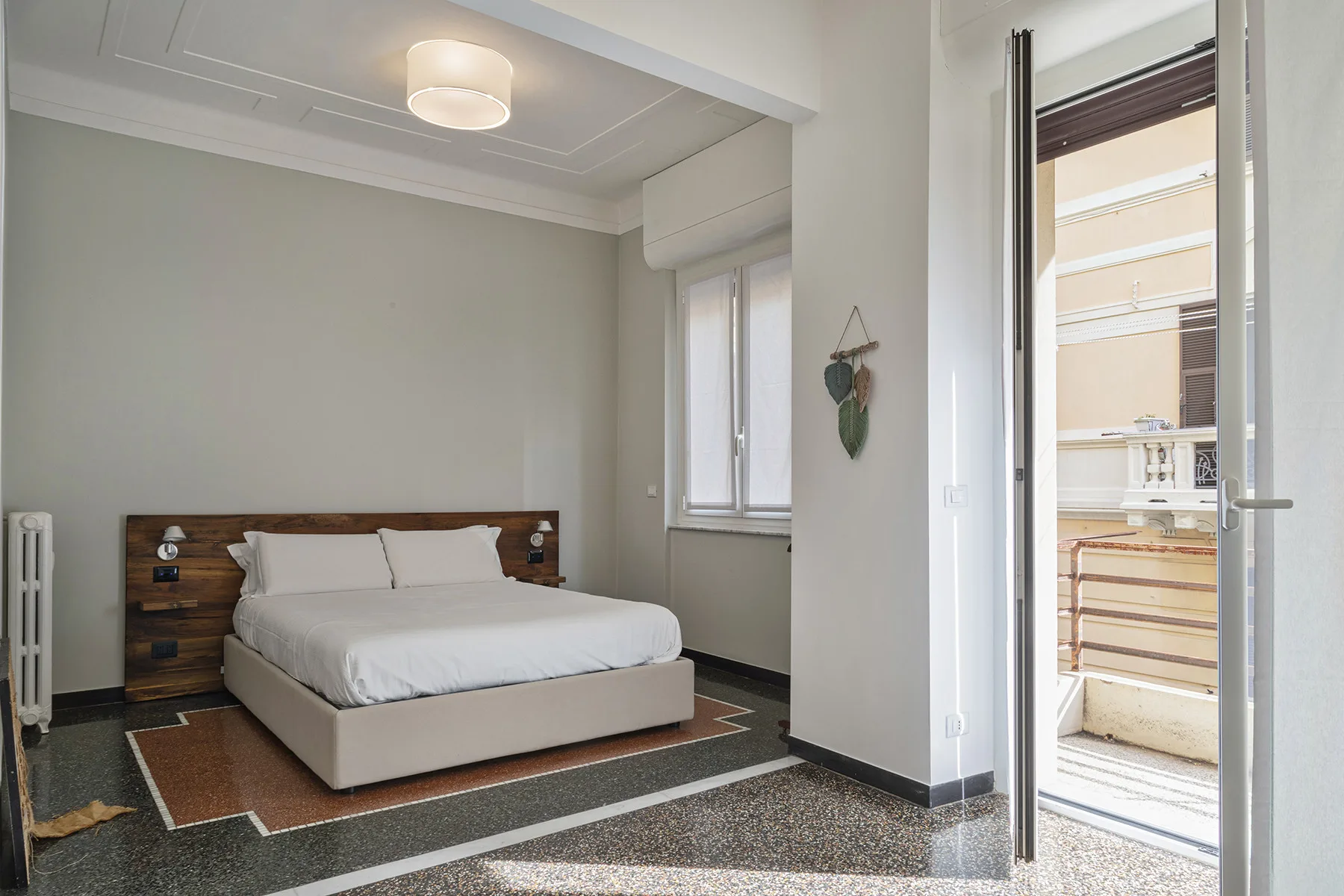 A bedroom with a double bed and an open doorway to a balcony.